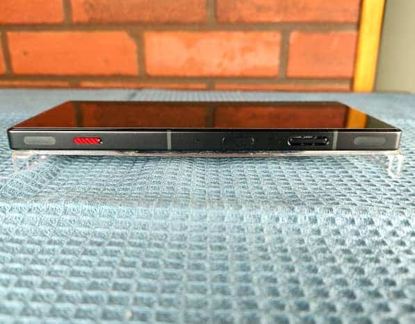 Bord droit : déclencheurs d'épaule, curseur rouge pour activer l'espace de jeu, le bouton d'alimentation et l'échappement du ventilateur